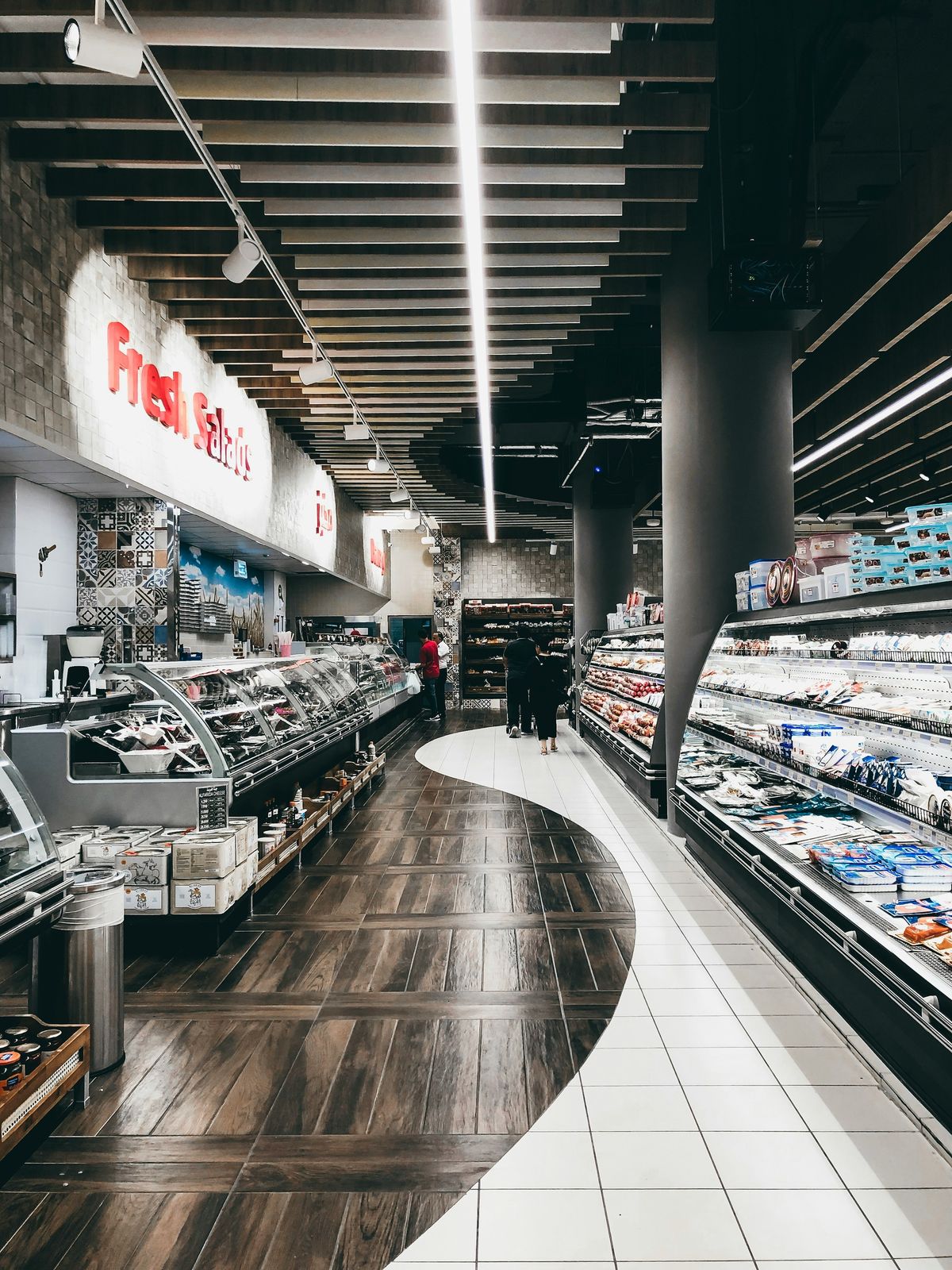 Elegant curved supermarket aisle lit by continuous light lines