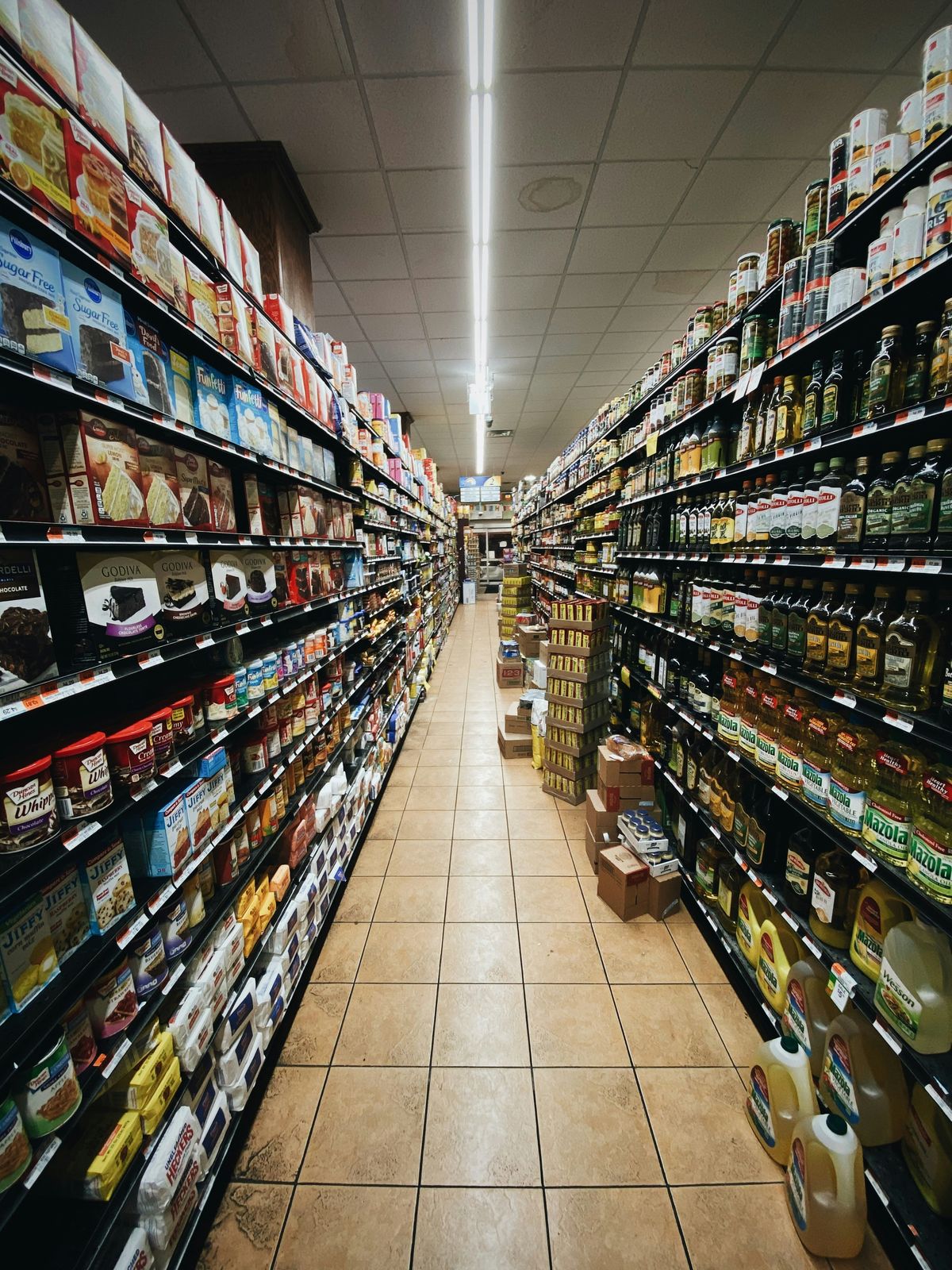 Dramatic downlight over a dark retail aisle