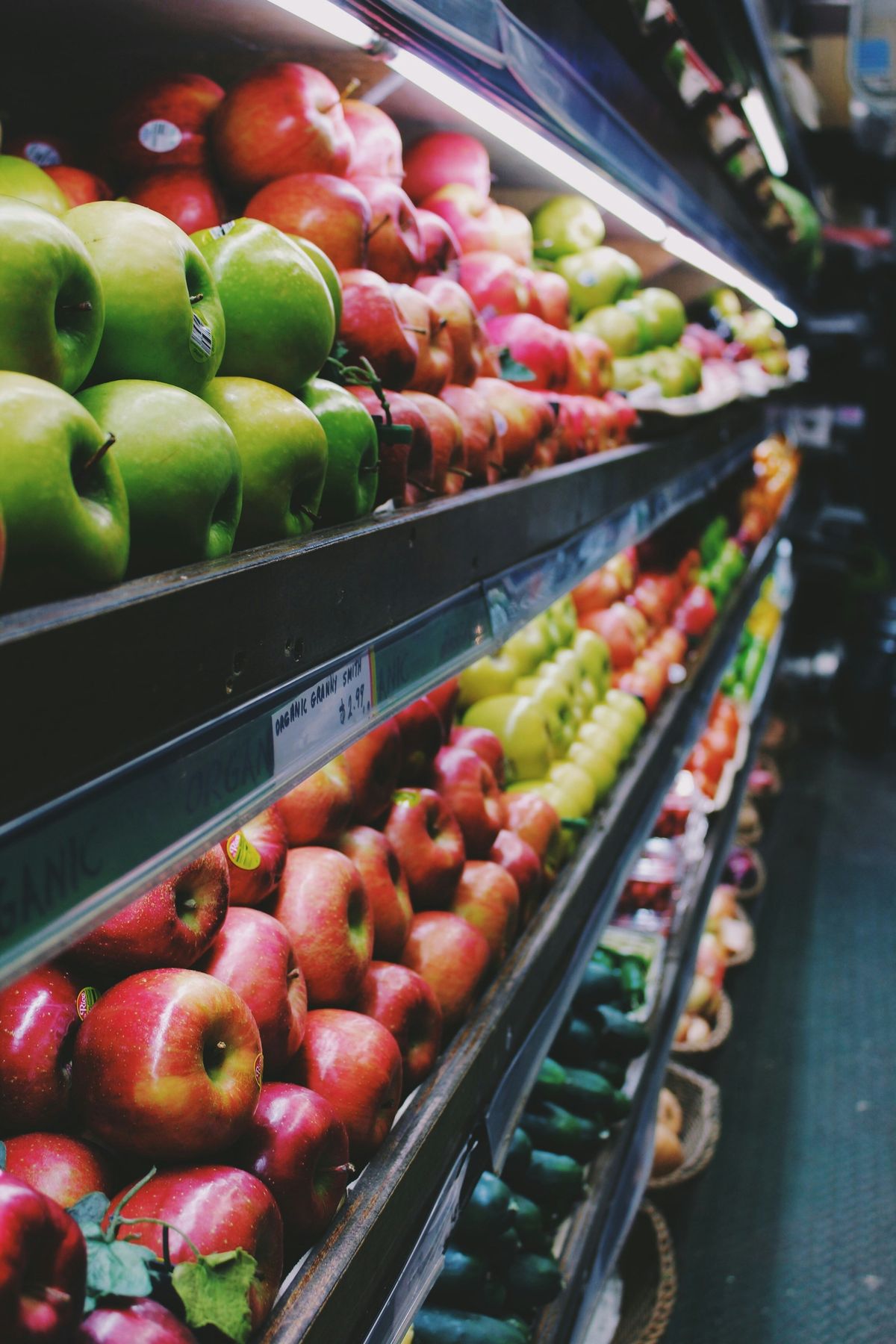 Fresh apples displayed under warm produce lighting