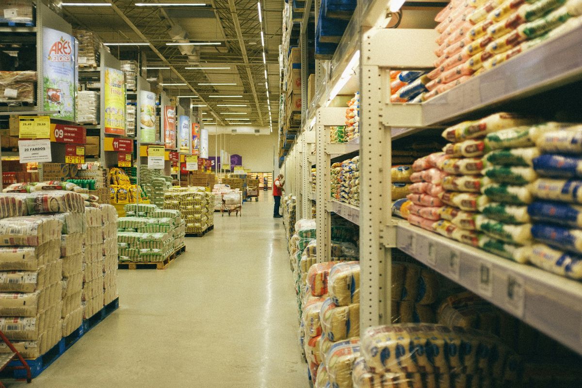 Shopper walking through a bright warehouse-style grocery store